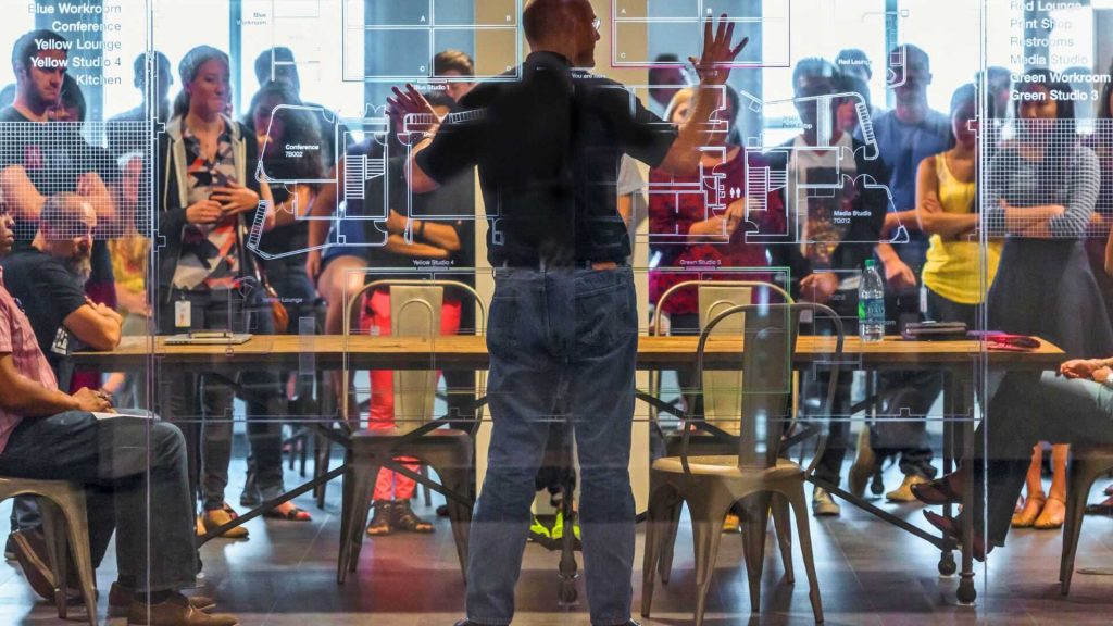 Photo of Phil Gilbert leading work session behind architecture glass